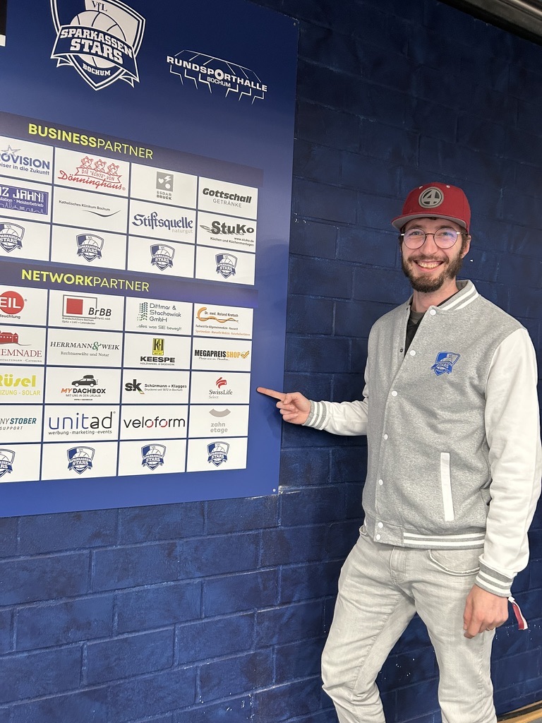 Nicholas Schwickrath vor der Sponsorenwand in der Rundsporthalle Bochum